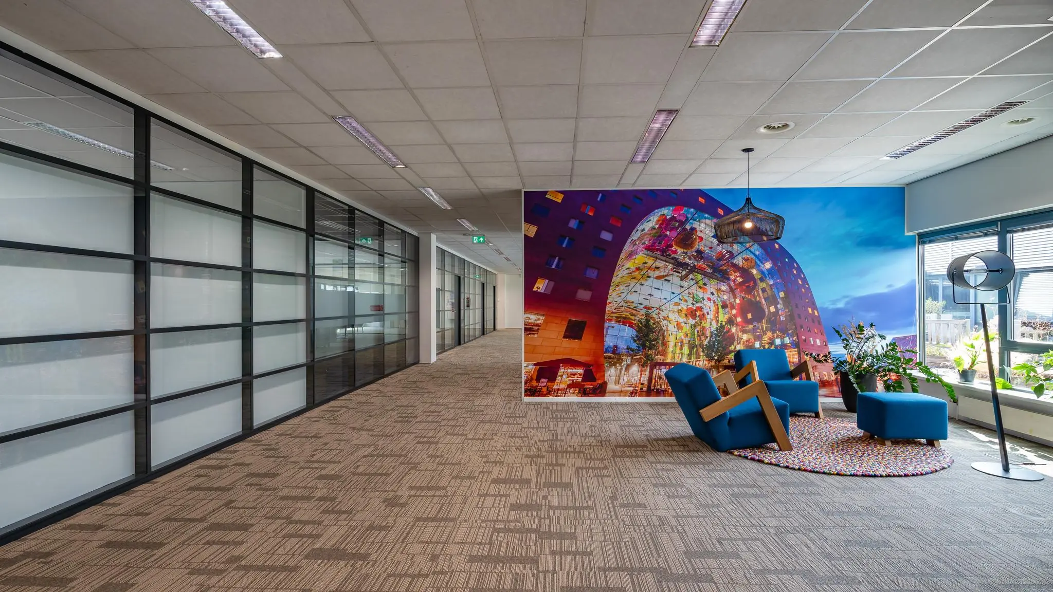 Moderne kantoorruimte aan de Rivium Boulevard met glazen wanden, loungehoek en grote wandfoto van de Markthal in Rotterdam.